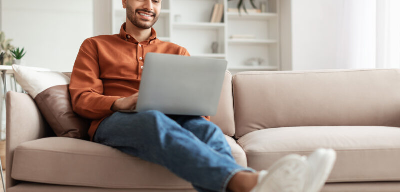 Man smiling at laptop.